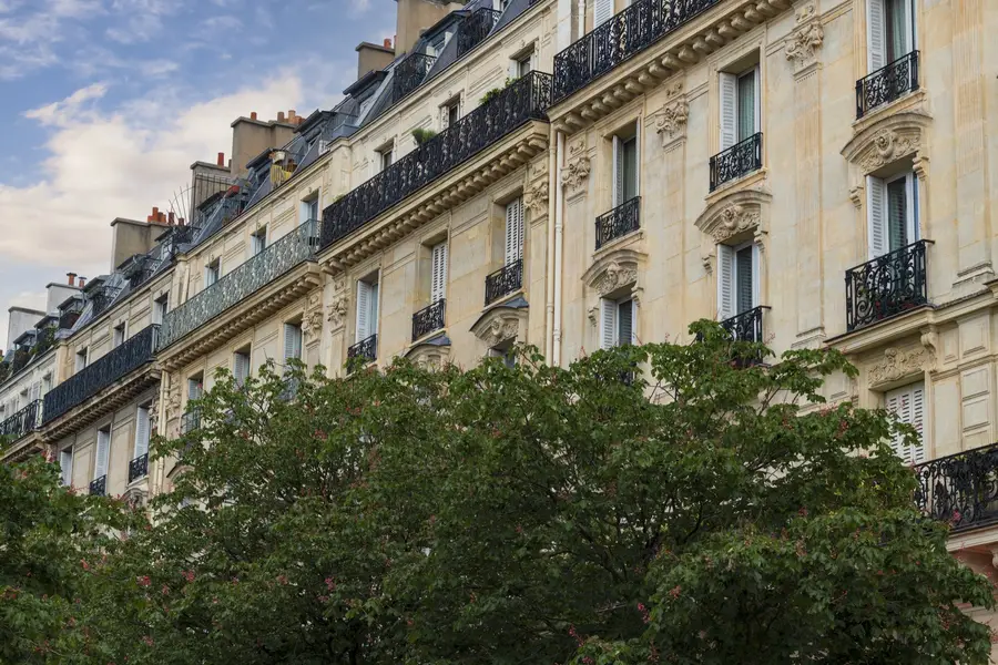 Façade d'immeuble haussmannien en pierre de taille avec balcons en fer forgé